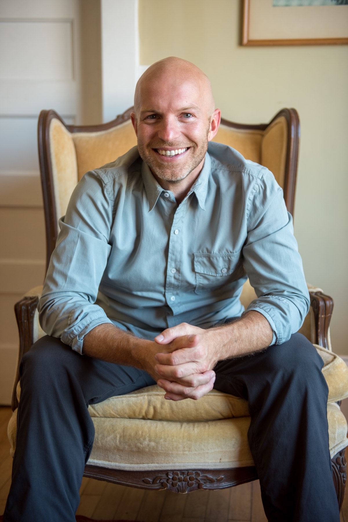 Dan Ronken seated in an armchair in his office, looking at the camera.